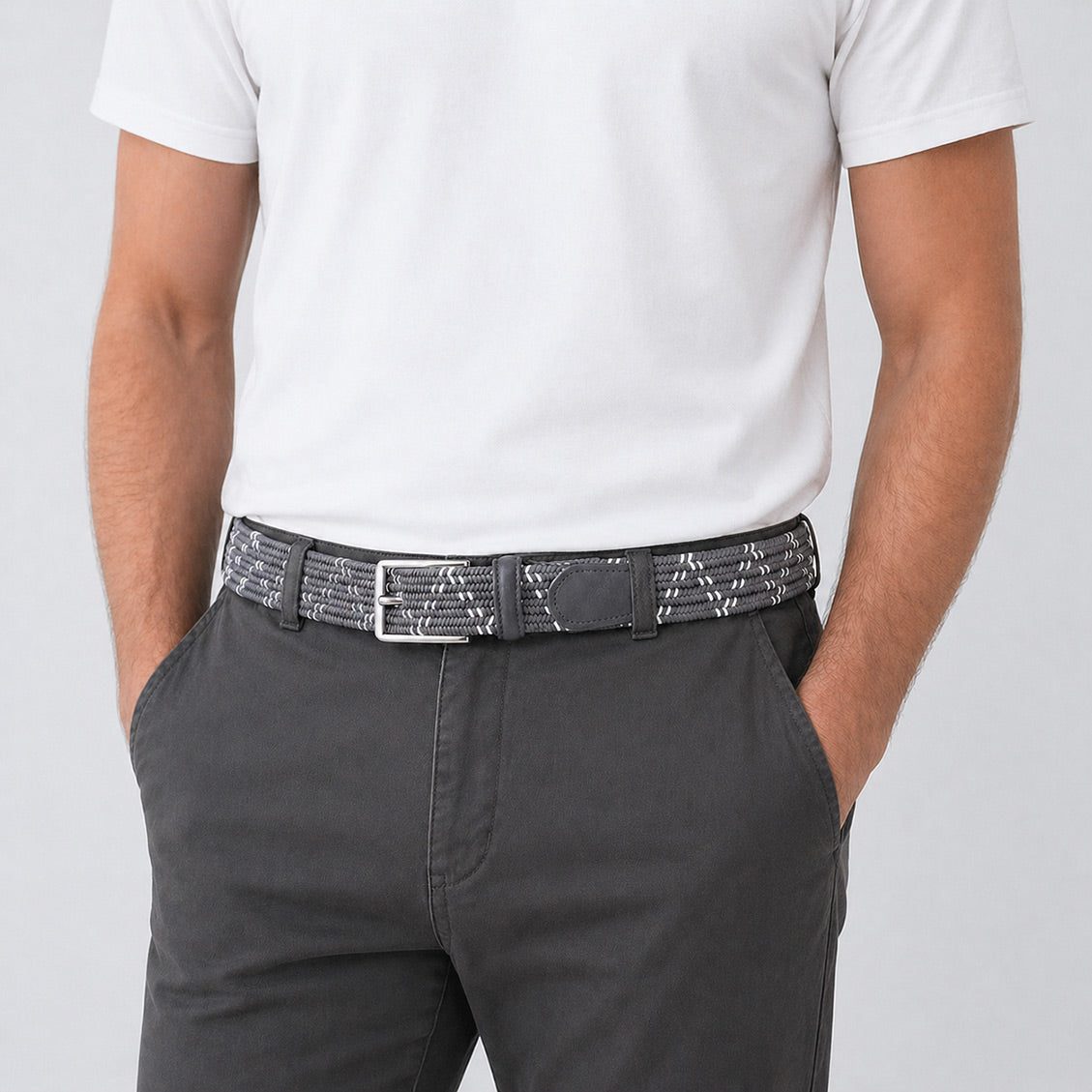 Person wearing a white shirt, gray pants, and a patterned mens belt