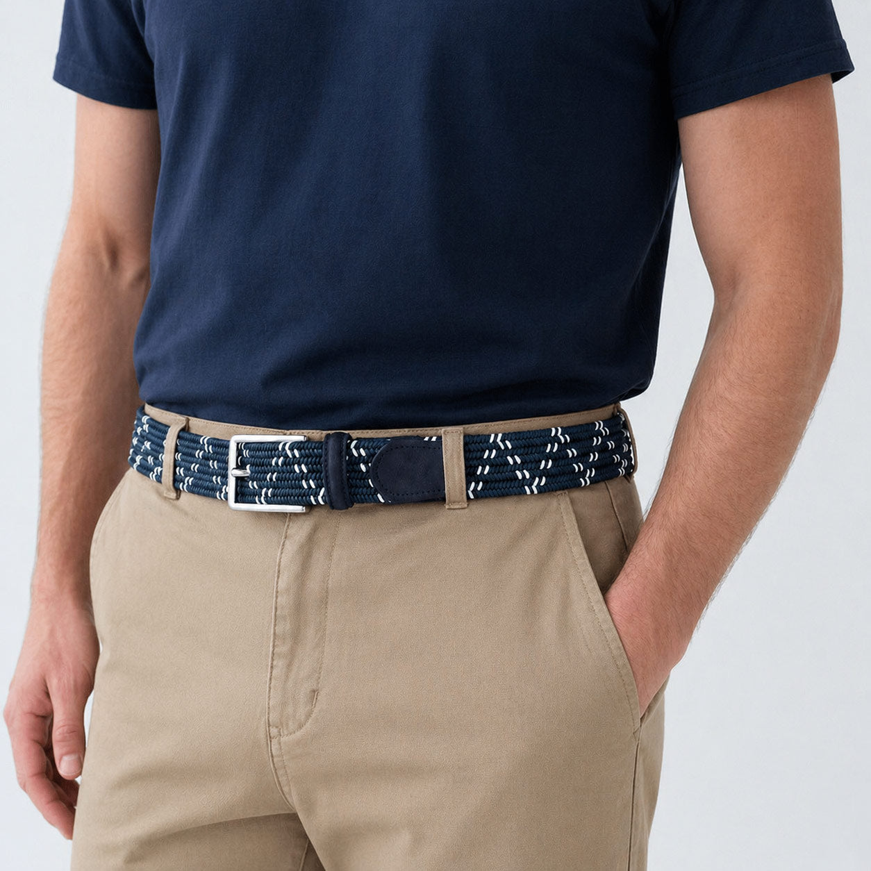 Person wearing a navy blue shirt and beige pants with a mens belt