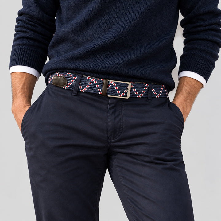 Man wearing a navy and white woven men’s belt with dark chinos and a navy sweater for a polished casual outfit