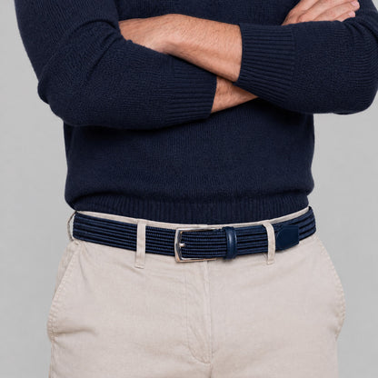Person wearing a navy sweater and beige pants with a navy mens belt 