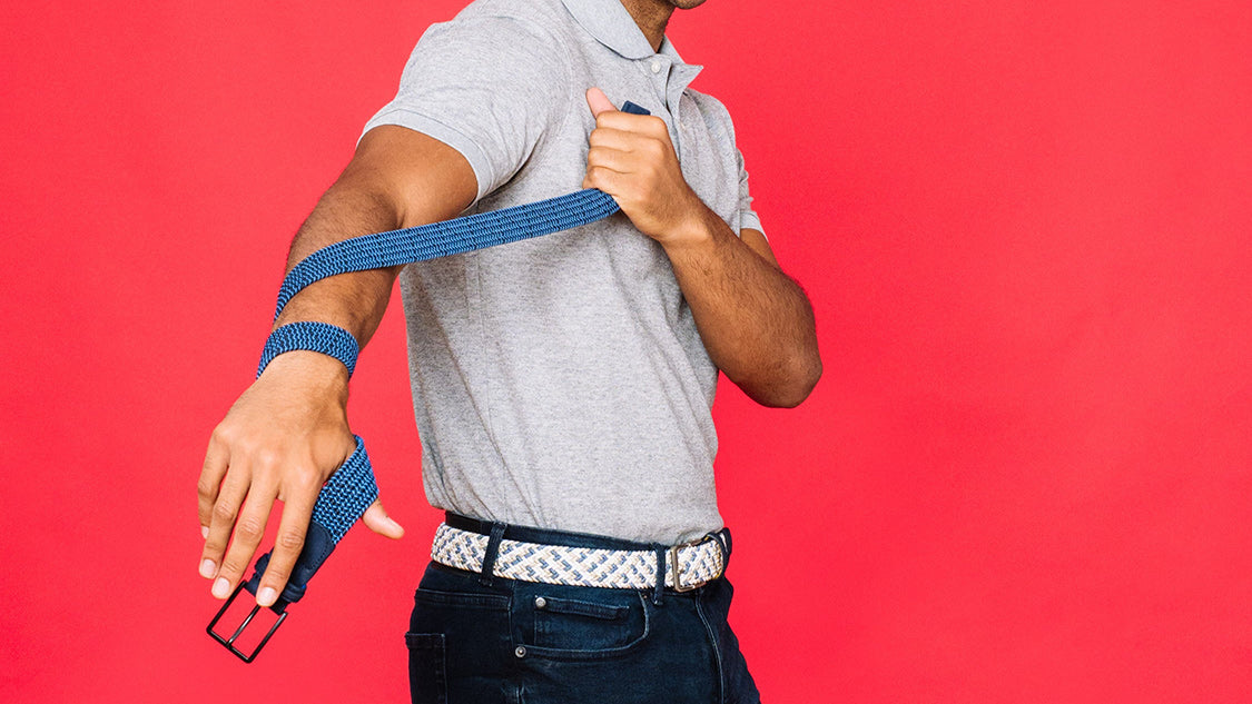 A man wearing a gray polo shirt and dark jeans and Beltology belt