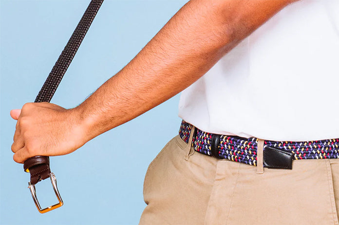 Person holding a colorful Beltology belt and beige pants