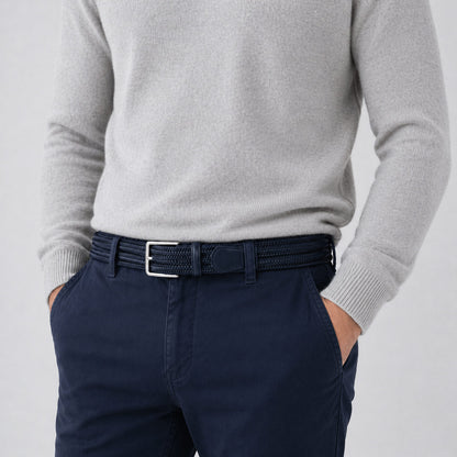 Person wearing a gray sweater and navy pants with a mens belt