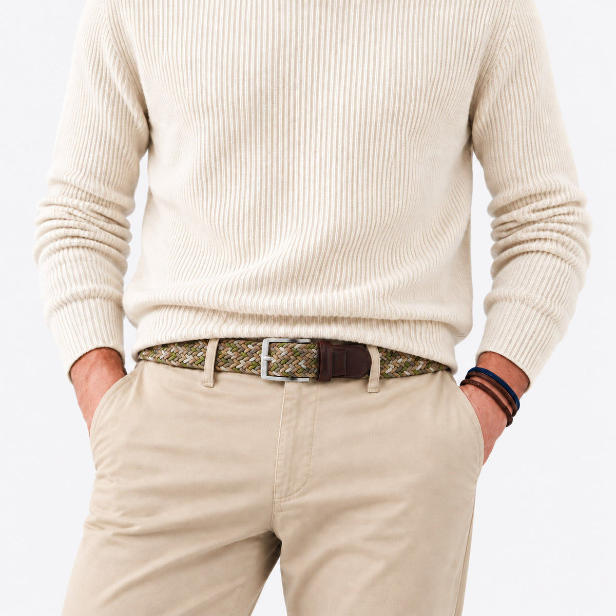 Man wearing the Chaos Khaki Grey Green men’s woven belt with beige chinos and a cream sweater