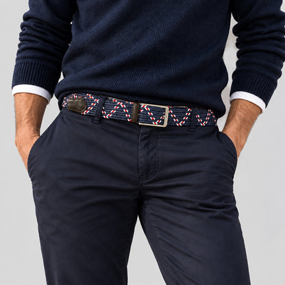 Man wearing a navy and white woven men’s belt with dark chinos and a navy sweater for a polished casual outfit